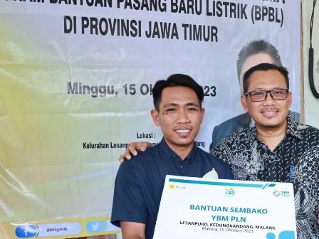 Senyum sumringah Joko Prasetyo (26) (kiri) saat menerima Bantuan Pasang Baru Listrik (BPBL) di Provinis Jawa Timur didampingi General Manager PLN UID Jawa Timur, Agus Kuswardoyo (kanan).
