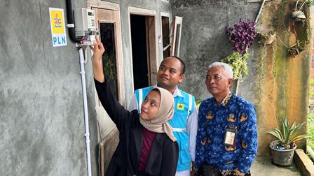 Penerima bantuan Program Light Up The Dream di Bantarsari, Kabupaten Cilacap, Jawa Tengah Putri Dwi Iwanti (kiri), menyalakan listrik rumahnya untuk pertama kalinya dampingi Manager PLN ULPSidareja, M. Yusuf Wibisana (tengah) dan Kepala Dusun Kamulyan, Sugiaji (kanan).
